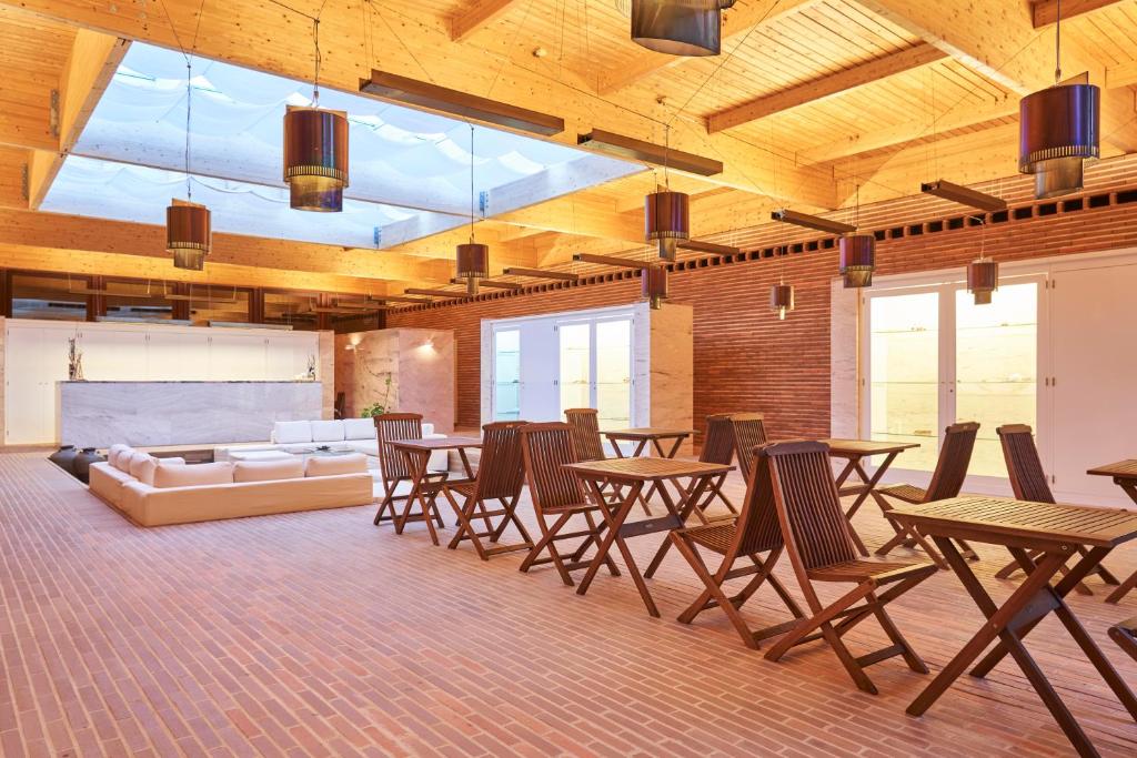 a room with tables and chairs and a couch at Hotel Porto Santo & Spa in Porto Santo