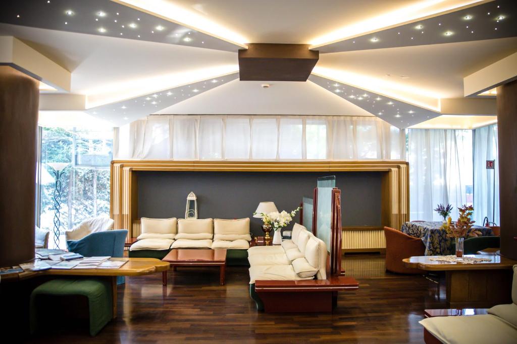 a waiting room with white couches and a fireplace at Hotel Citta' Di Conegliano in Conegliano