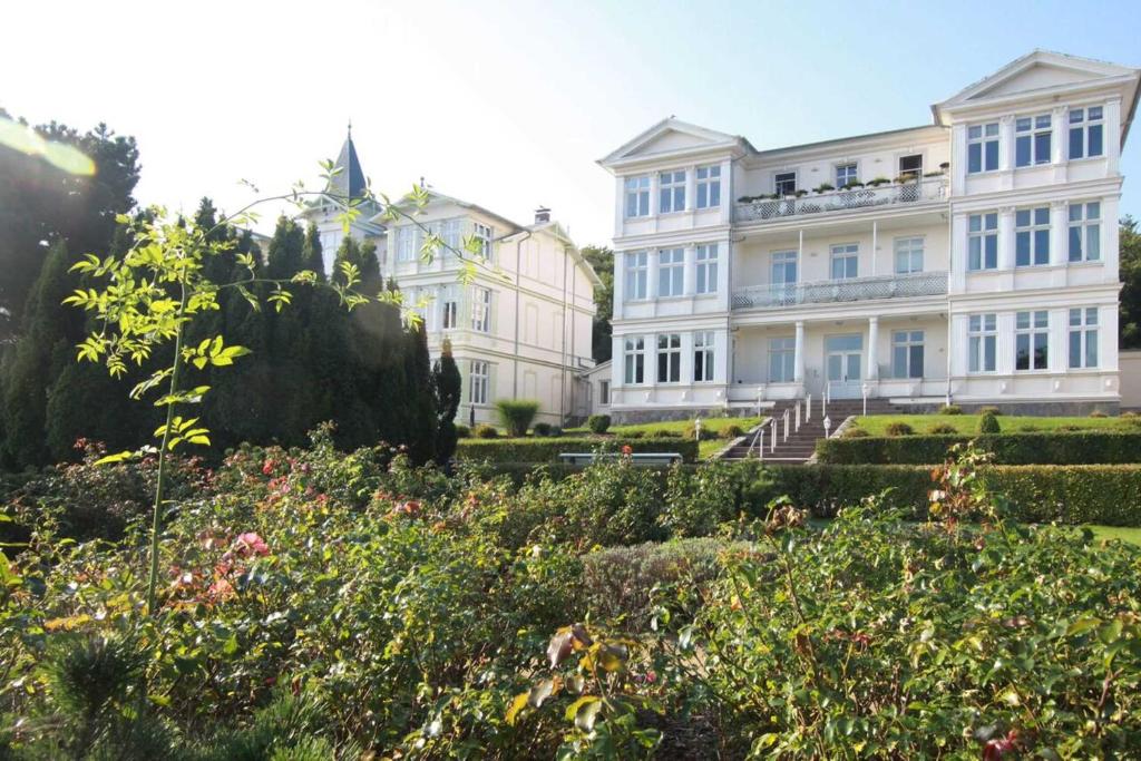 a large white building with a garden in front of it at Duene25 in Zinnowitz