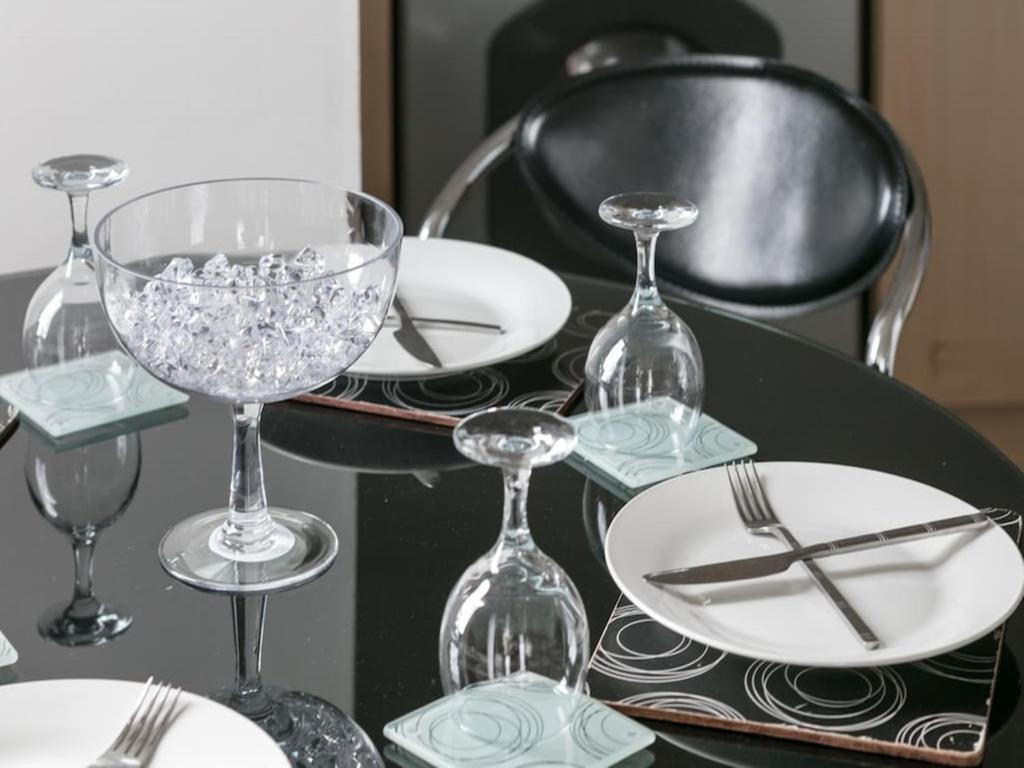 a black table with wine glasses and plates on it at Business long stay rates 56 in Manchester