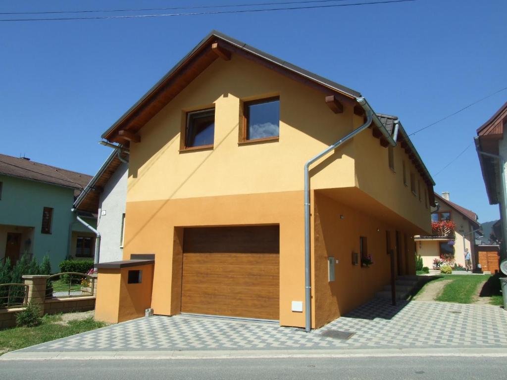 a house with a garage with at Ubytovanie na Roháčskej in Zuberec