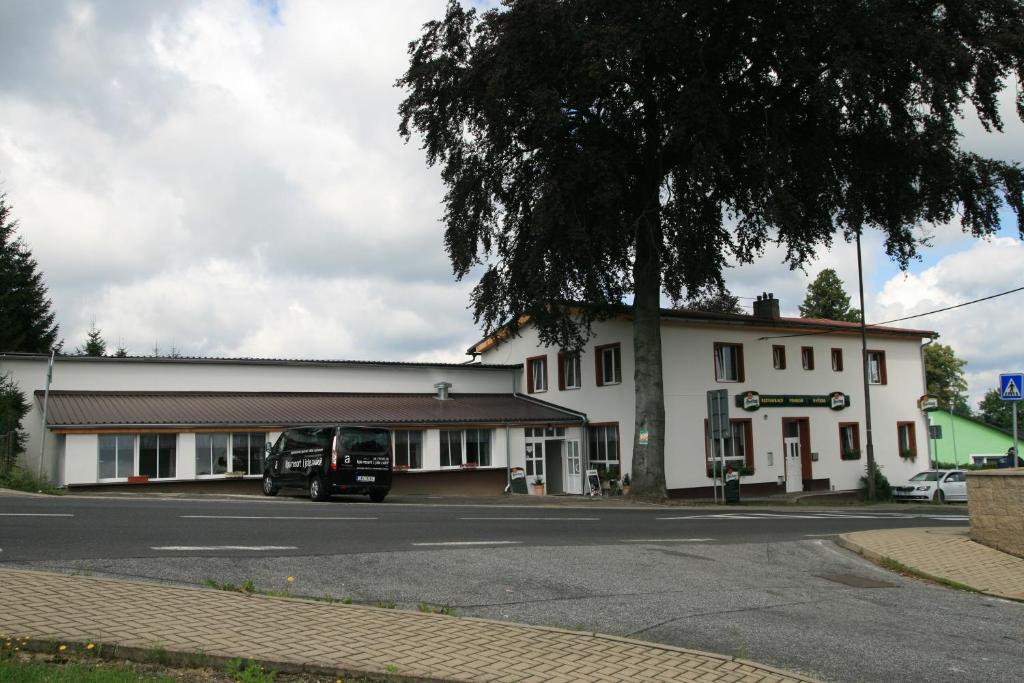 a white building with a van parked in front of it at Penzion Hvězda - Restaurace dočasně uzavřena in Rumburk