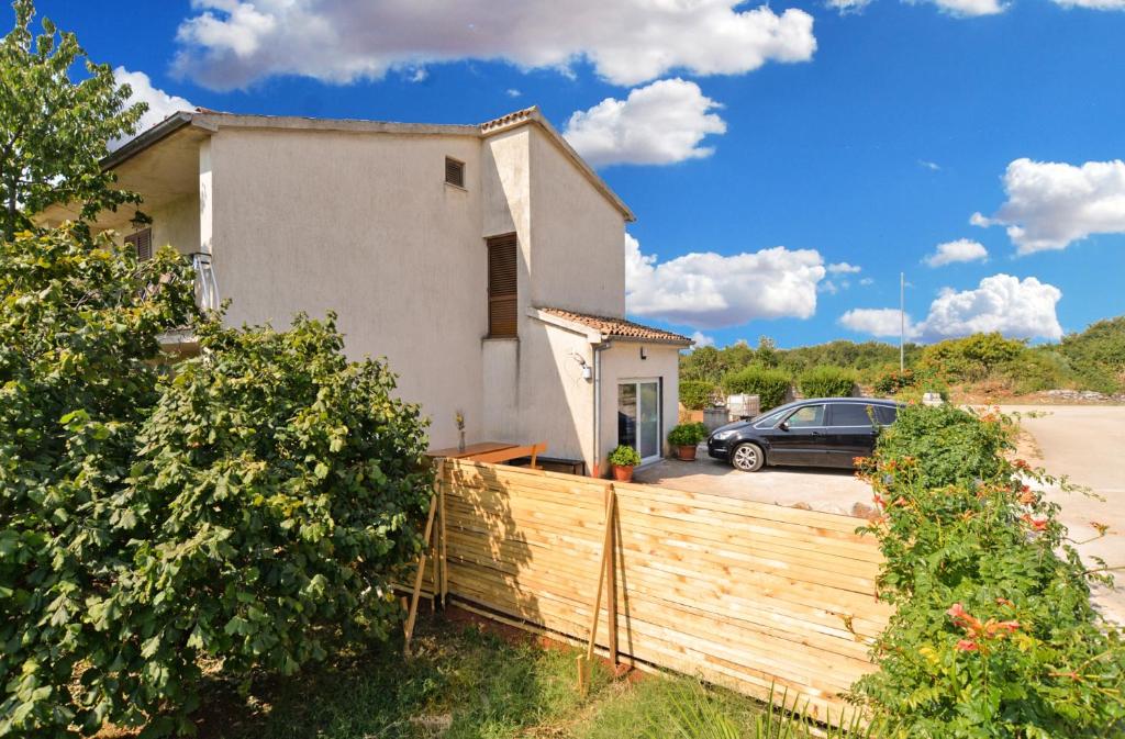 a house with a fence and a car in front of it at Apartment Mirella 1745 in Bale