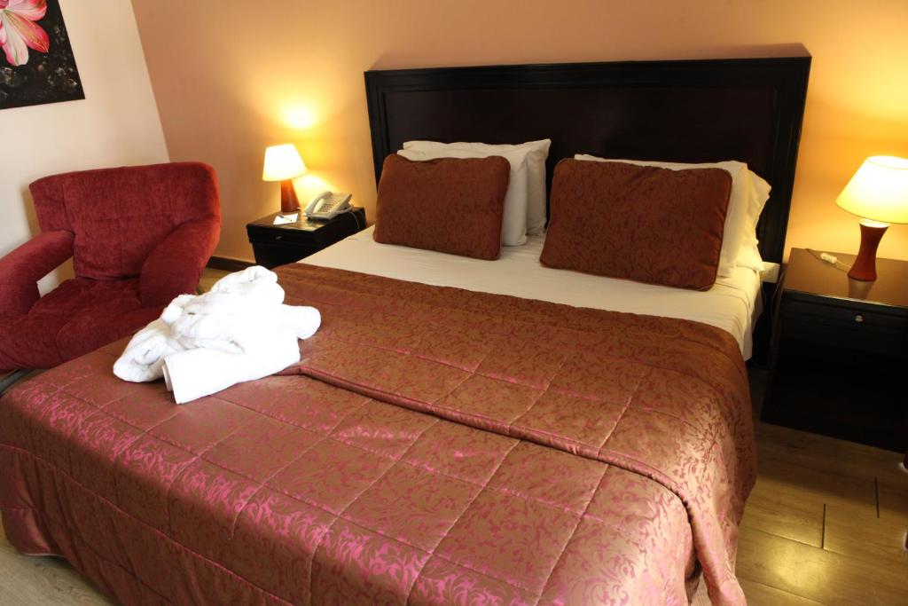 a hotel room with a bed and a red chair at Mozart Hotel in Beirut