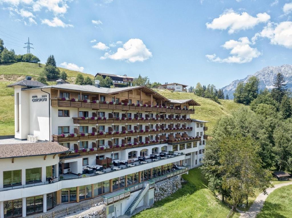 un hotel en las montañas con montañas en el fondo en Familienhotel Christoph en Ellmau