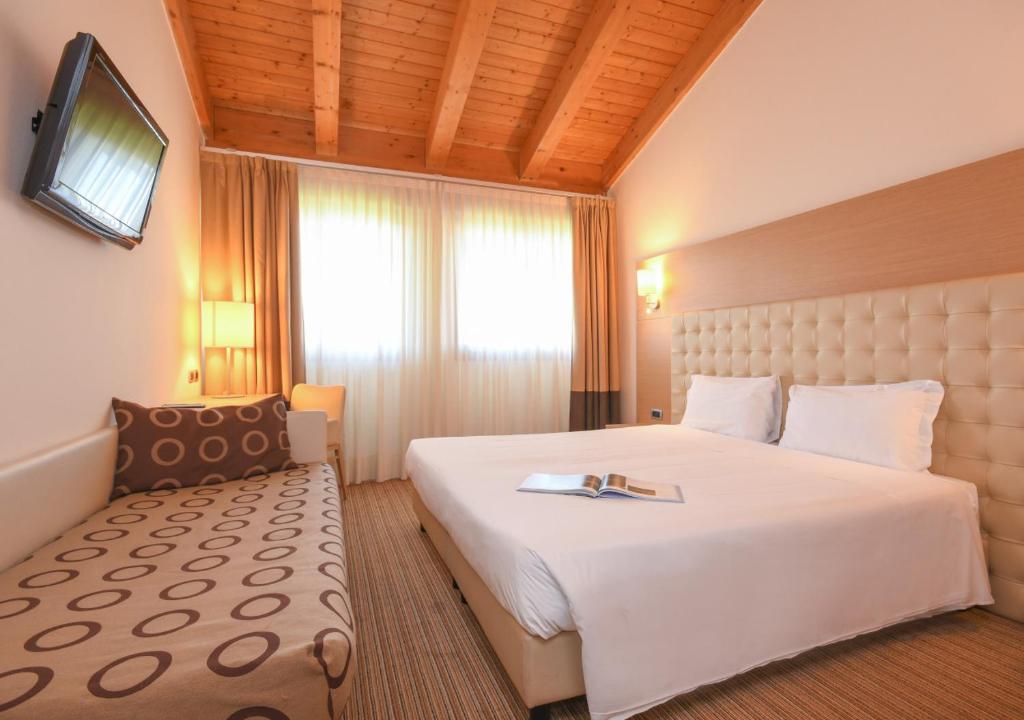 Postel nebo postele na pokoji v ubytování TH Lazise - Hotel Parchi Del Garda