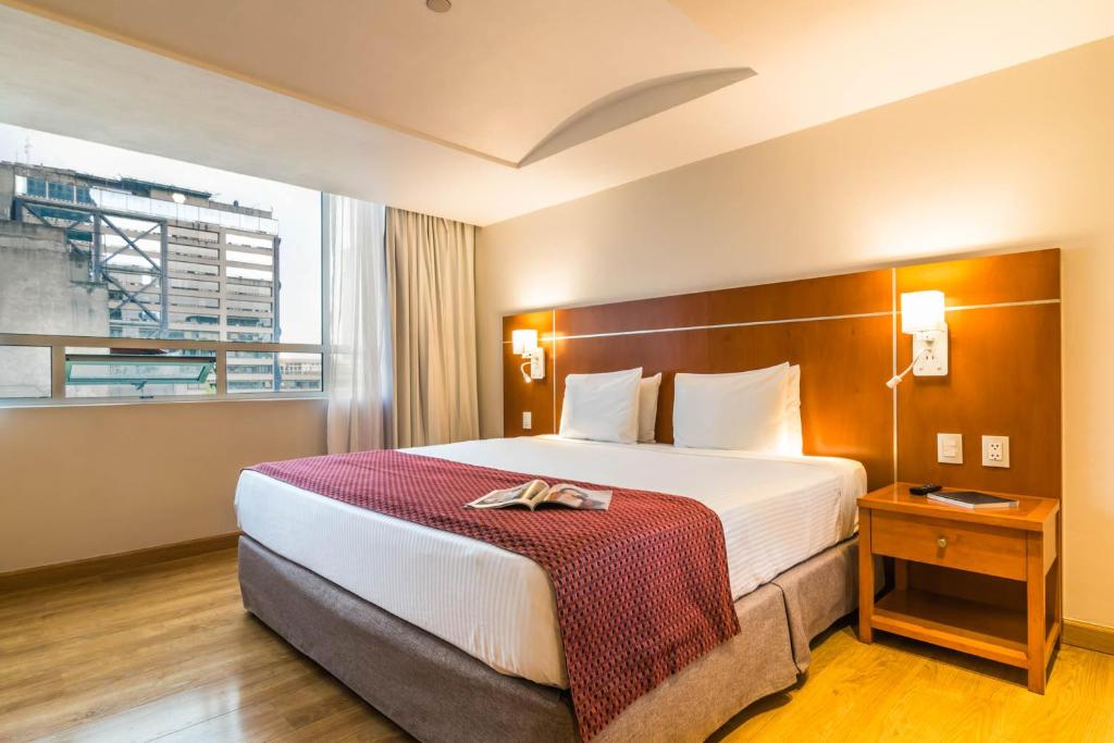 a hotel room with a large bed and a window at Eurostars Zona Rosa Suites in Mexico City