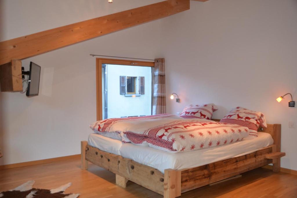 a bedroom with a wooden bed with pillows on it at Chalet Truffer Ulrichen in Ulrichen