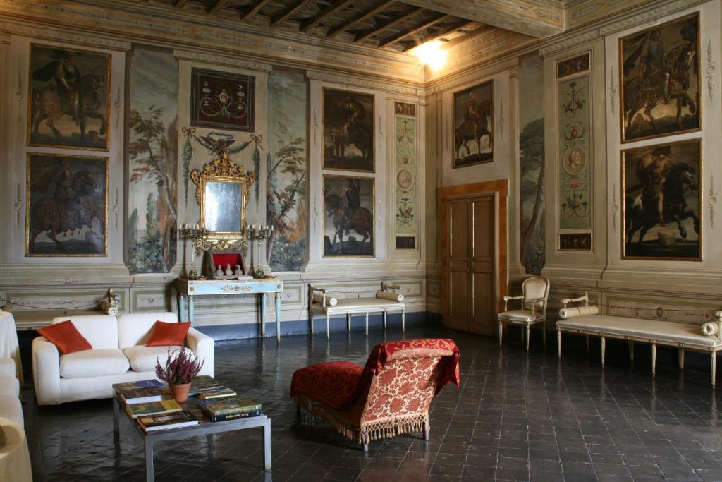 ein Wohnzimmer mit Gemälden an den Wänden in der Unterkunft VesConte Residenza D'epoca dal 1533 in Bolsena
