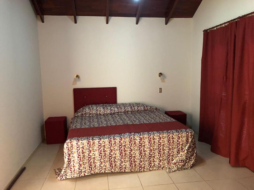 a bedroom with a bed with a red curtain at La casona de ensueño in Formosa