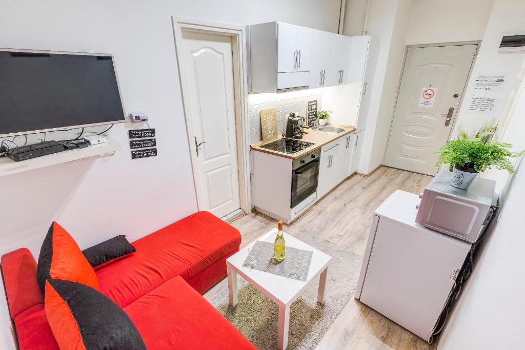 ブダペストにあるReal Apartments Kertész II.のリビングルーム(赤いソファ付)、キッチン