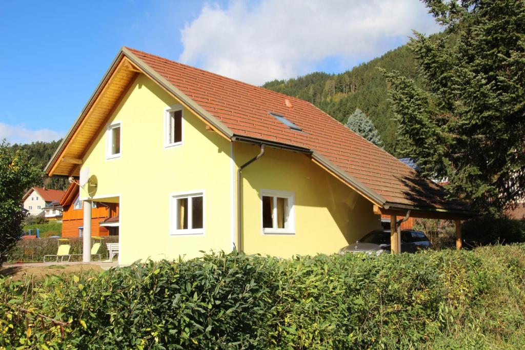 une maison jaune avec un toit rouge dans l'établissement Narrenhaus, à Fohnsdorf