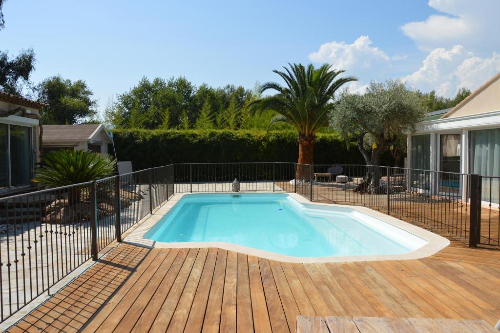 una piscina en una terraza con una valla en Les 2 roses De Verdillon en La Crau