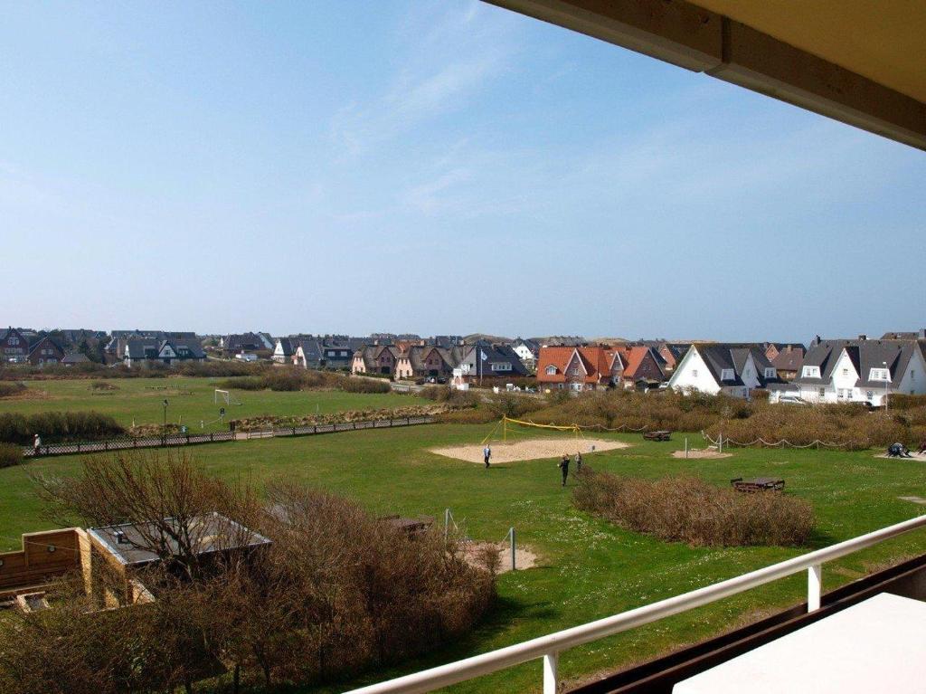 einen Blick auf ein Feld mit Häusern im Hintergrund in der Unterkunft Ahrendt - Seestern in Wenningstedt-Braderup