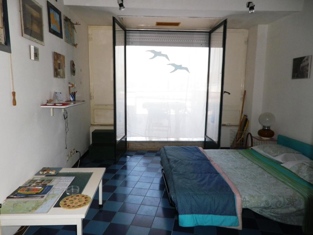 1 dormitorio con cama, mesa y ventana en pietre nere, en Giardini Naxos