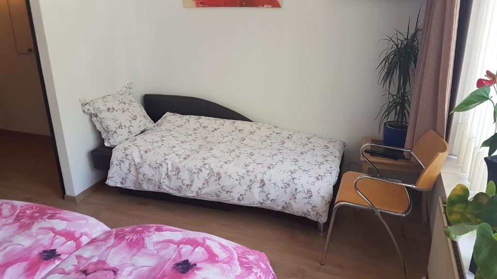 ein kleines Schlafzimmer mit einem Bett und einem Stuhl in der Unterkunft B&B Harskamp in Harskamp