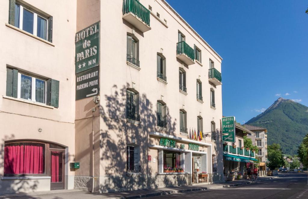 a building with a sign on the side of a street at Hôtel De Paris in Briançon