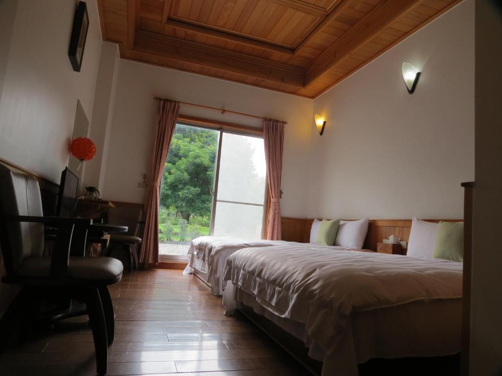 a bedroom with two beds and a window at Seasons Inn in Jiaoxi