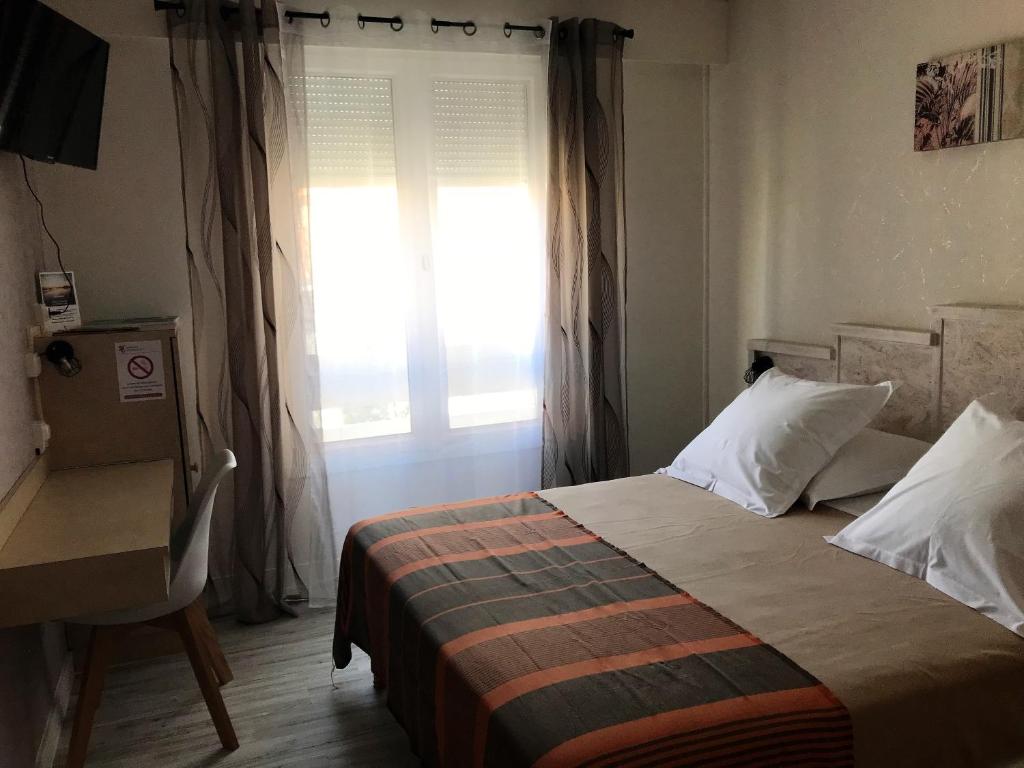 um quarto com uma cama e uma janela em Hôtel du Commerce em Les Sables-dʼOlonne