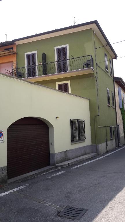 zielony i biały budynek z garażem w obiekcie B&B I Lazzarini w mieście Sarnico