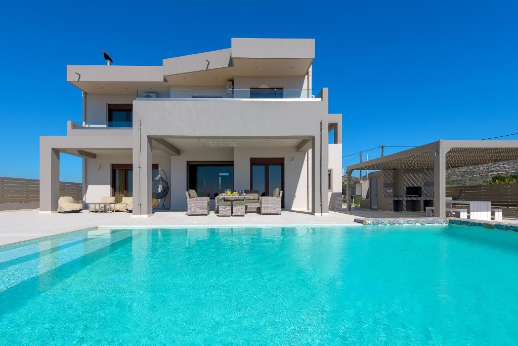 a villa with a swimming pool in front of a house at Alav Pool Villa in Afantou