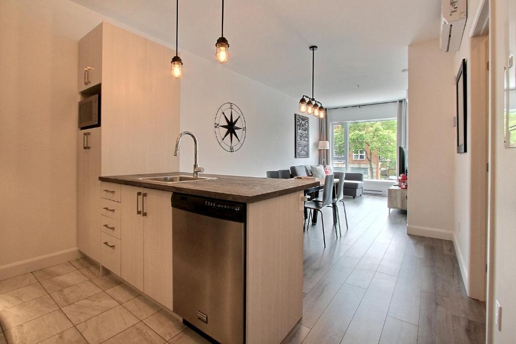 a kitchen with a sink and a counter top at INITIAL - PILOTE - Centre-Ville de Québec in Quebec City