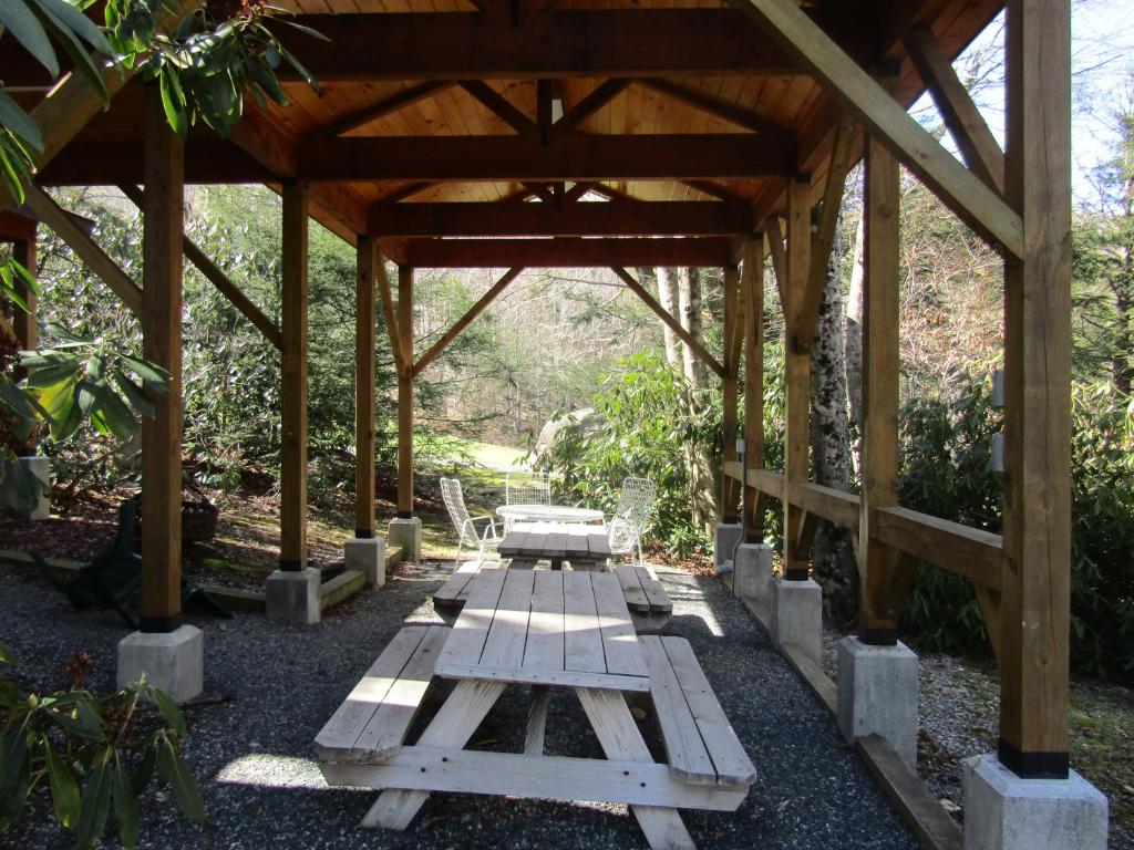 - un pavillon en bois avec une table de pique-nique au milieu dans l'établissement The Glen II Unit 59 Condo, à Sugar Mountain