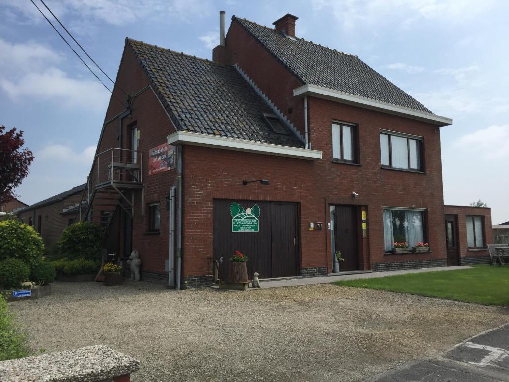 a red brick house with a garage at Vakantiehuis Loft André in Leke