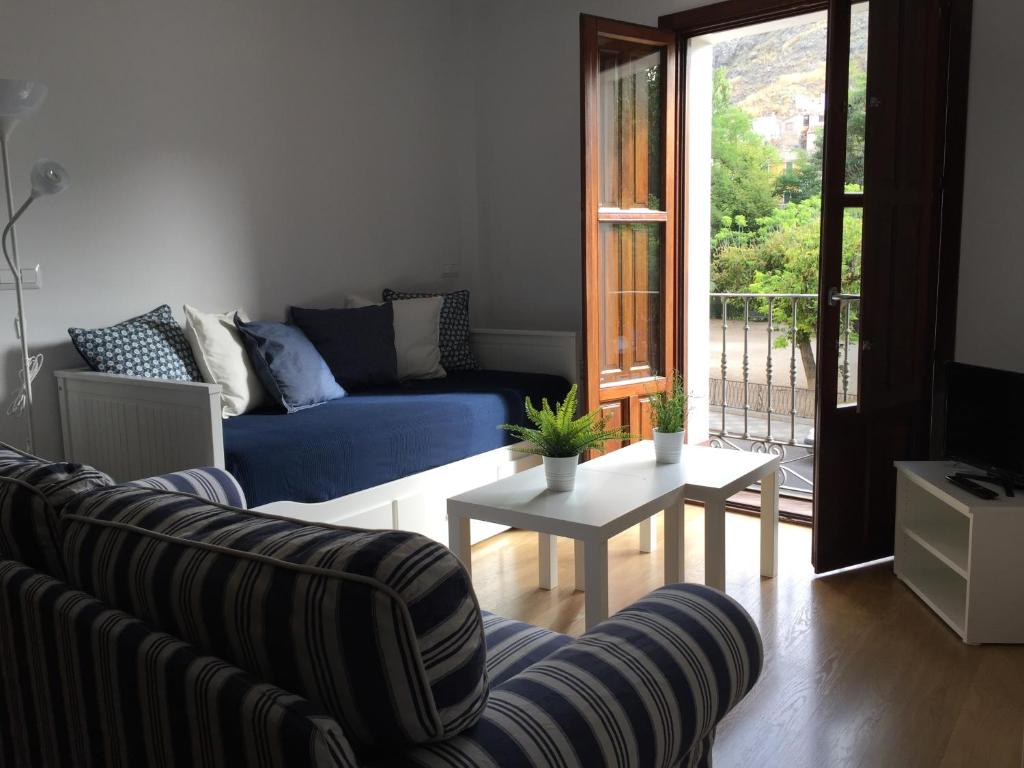 un soggiorno con un divano e un tavolo di Apartamentos Viejo Continente a Cuenca