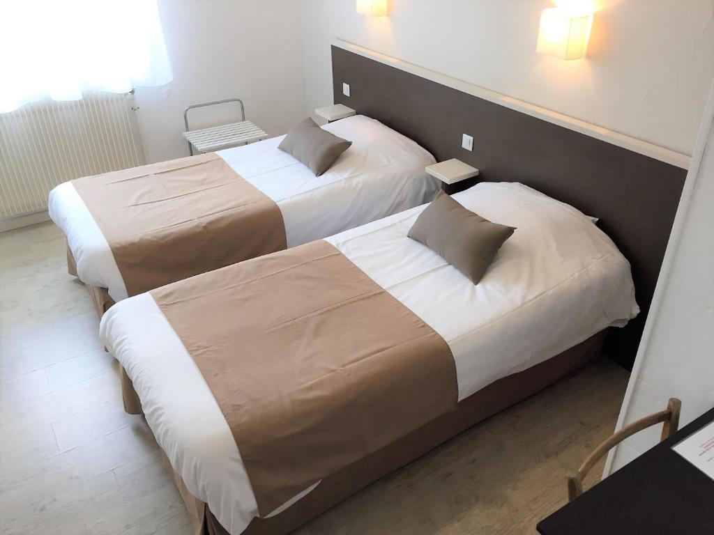 two beds in a hotel room next to each other at Auberge Les Mufliers - Hôtel Les Forges in Pontenx-les-Forges
