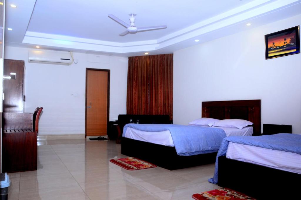 a hotel room with two beds and a ceiling at Hotel Skypark, Sreemangal in Sreemangal