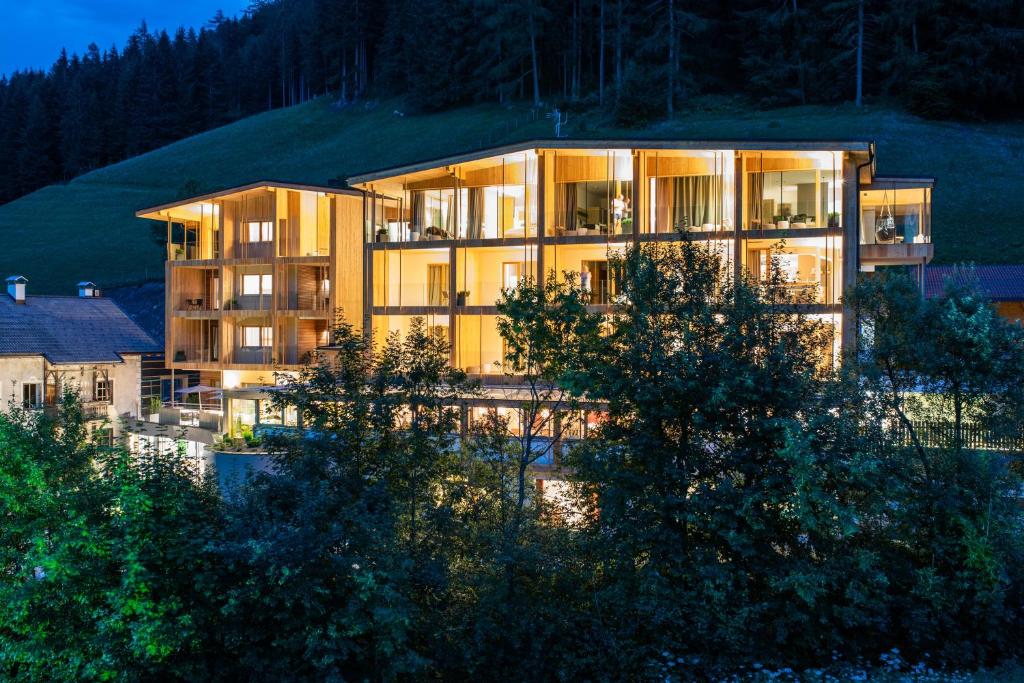 un grande edificio con luci accese di fronte di Naturhotel Rainer a Racines