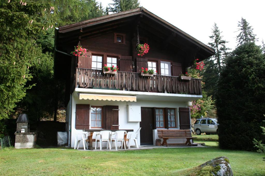 ein Haus mit einem Balkon sowie Tischen und Stühlen in der Unterkunft Vergissmeinnicht in Blatten bei Naters