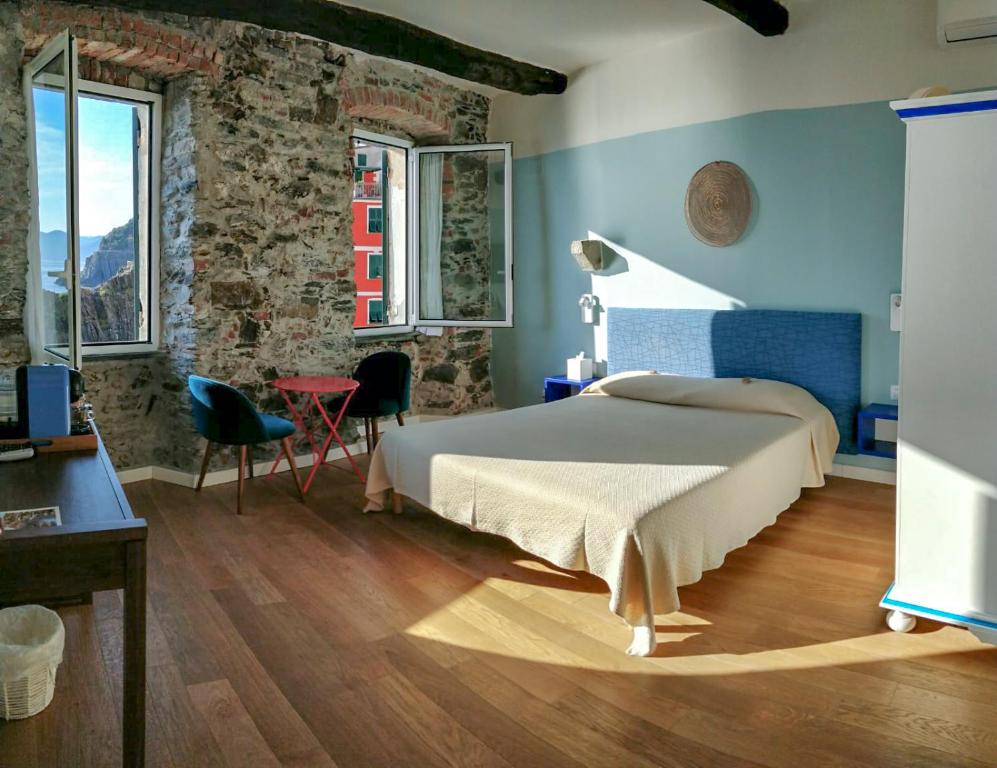 Schlafzimmer mit einem Bett, einem Tisch und Stühlen in der Unterkunft Orto al Mare Room Rental in Riomaggiore