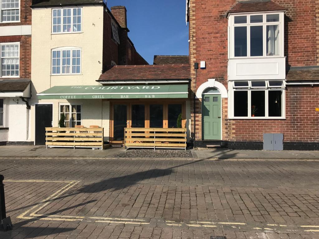 a building with two wooden benches in a street at The Courtyard in Bewdley
