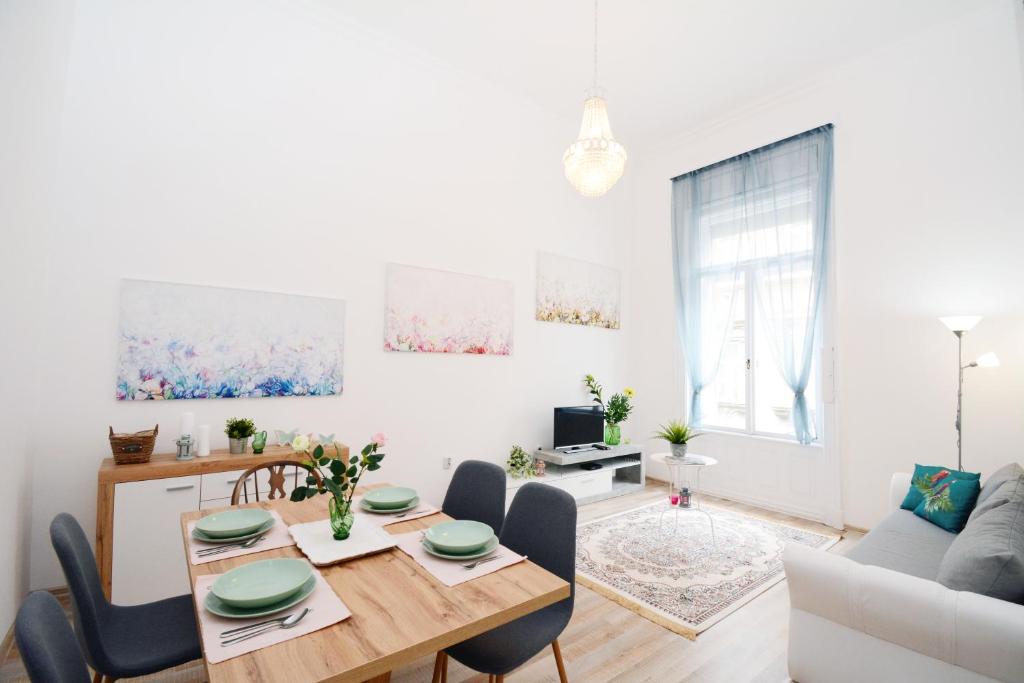 ブダペストにあるLillybeth City Center Apartmentsの白いリビングルーム(テーブル、椅子付)