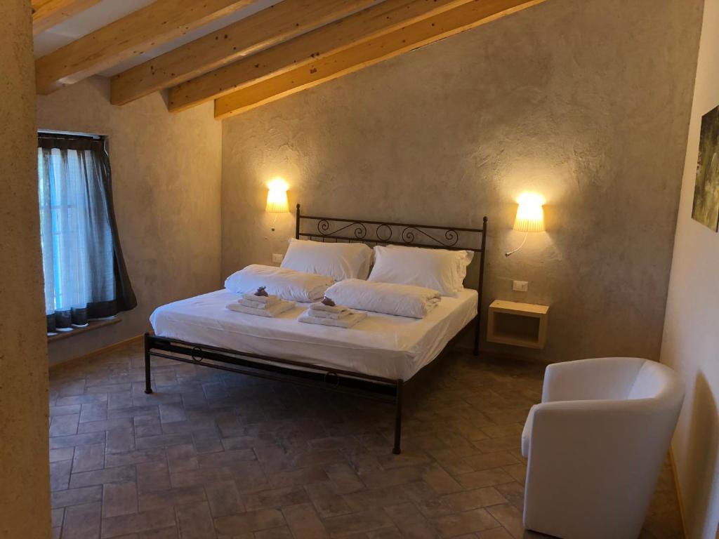 ポンティ・スル・ミンチョにあるagriturismo2laghiのベッドルーム1室(ランプ2つ、椅子付)
