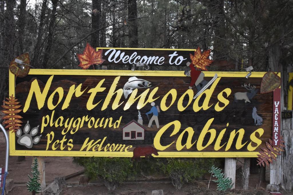 Un signo que dice bienvenidos al norte. No salgáis con mascotas. en Northwoods Resort Cabins, en Pinetop-Lakeside