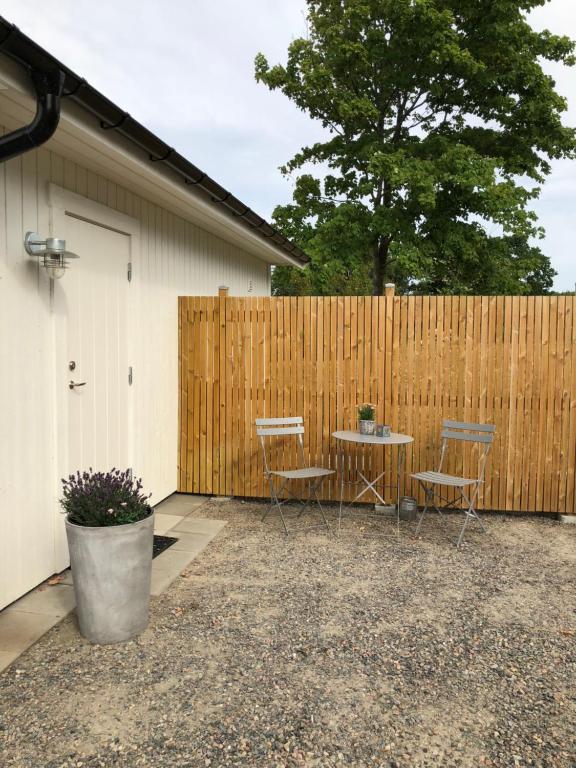 un patio con mesa y sillas frente a una valla en Annelund, en Varberg