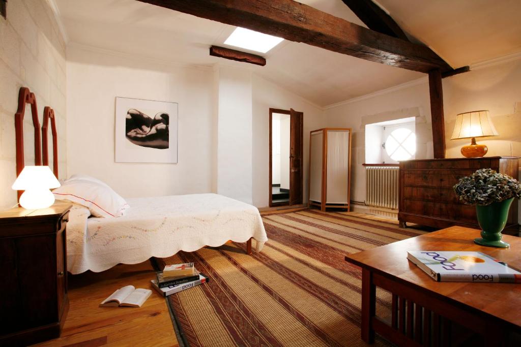 Un dormitorio con una cama y una mesa. en La Porte Rouge - The Red Door Inn, en Saintes