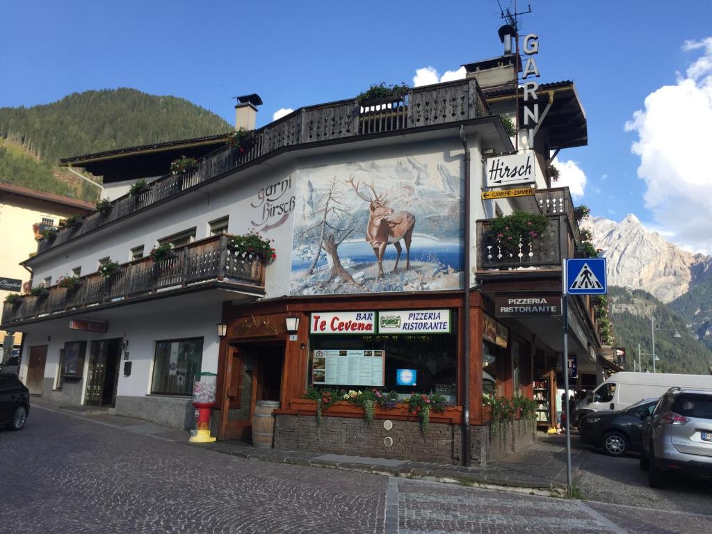 a building with a large mural of a deer on it at Garni Hirsch in Canazei