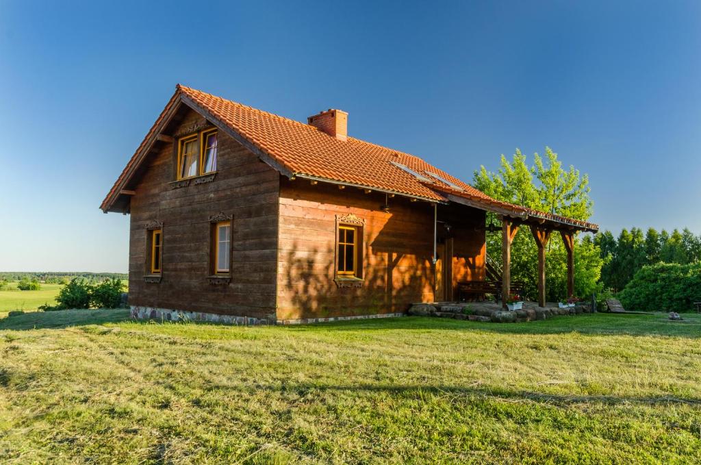 una casa vieja en medio de un campo en Domek na Górce en Sorkwity