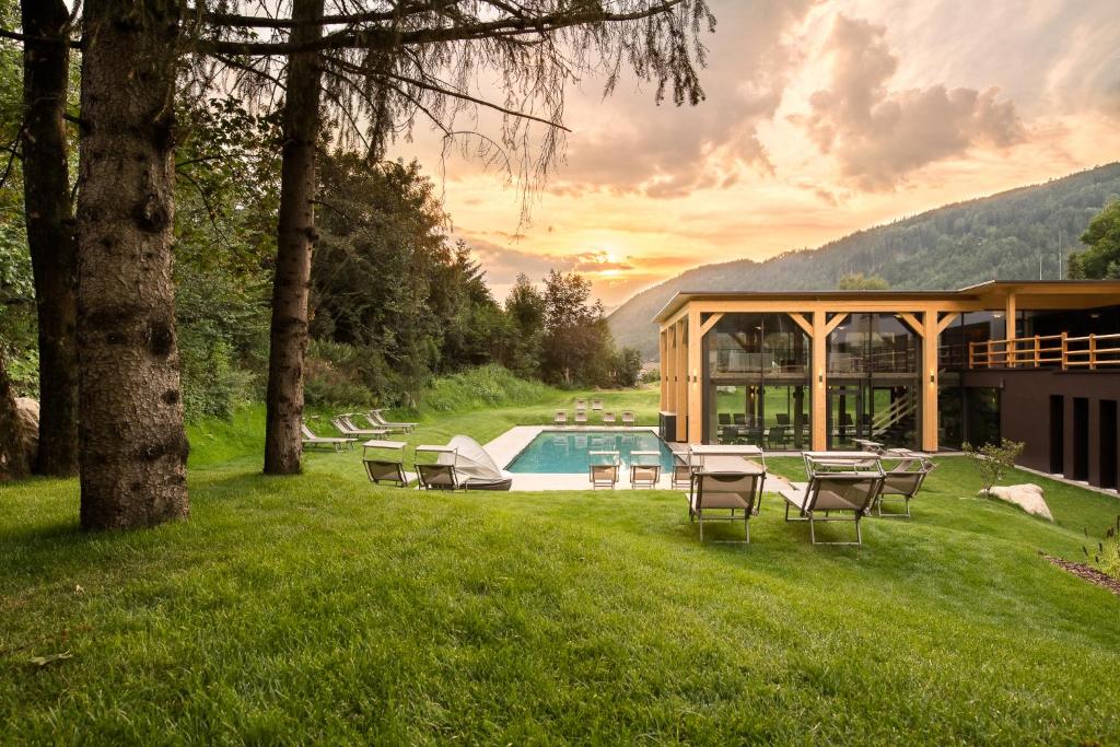 a house with a swimming pool in the grass at Hotel Pustertalerhof in Chienes