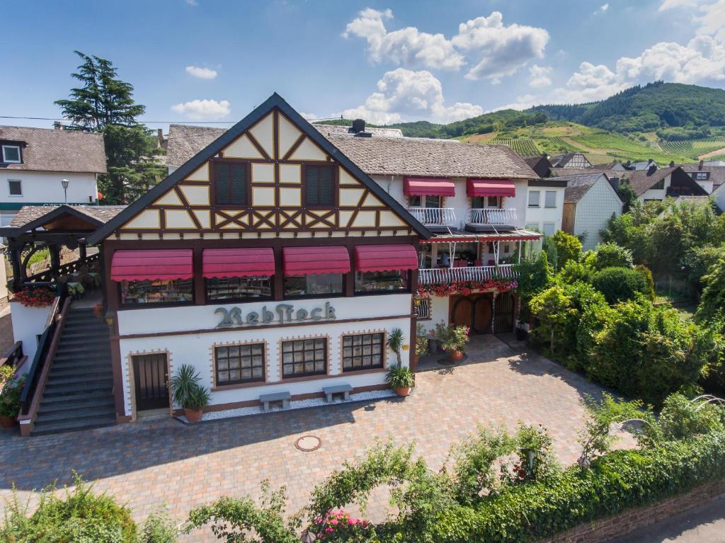 un viejo edificio con toldos rojos. en Hotel Rebstock, en Bruttig-Fankel