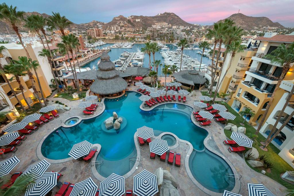 an aerial view of a resort pool with chairs and umbrellas at Marina Fiesta Resort & Spa, A La Carte All Inclusive Optional in Cabo San Lucas