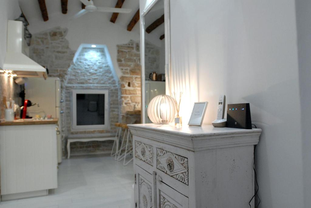 - une cuisine avec un mur en pierre et un comptoir dans une pièce dans l'établissement Apartman tutto bene, à Rovinj
