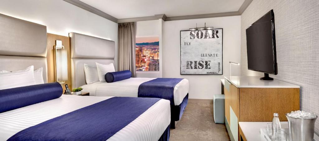 a hotel room with two beds and a tv at The STRAT Hotel, Casino and SkyPod in Las Vegas