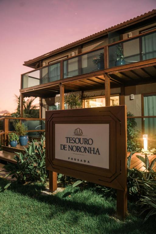 a sign in the grass in front of a building at Tesouro de Noronha in Fernando de Noronha