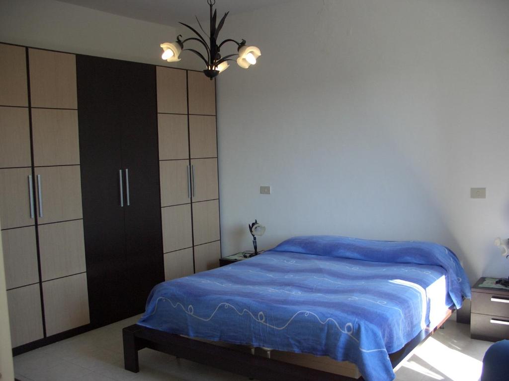 a bedroom with a bed with a blue blanket at Blu Mariner in Vada