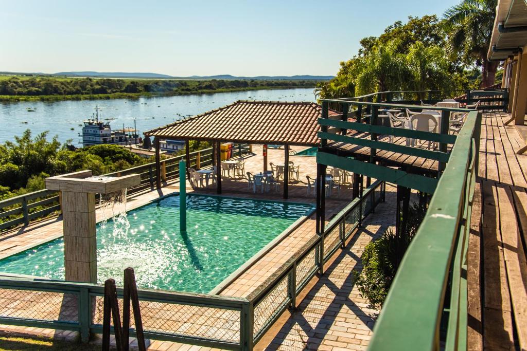 a large swimming pool with a gazebo next to a river at Candeias Hotel Gold Fish in Corumbá